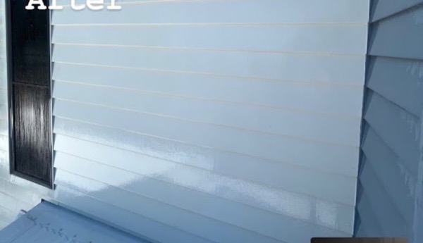 A close view of a pale blue-grey rendered house wall